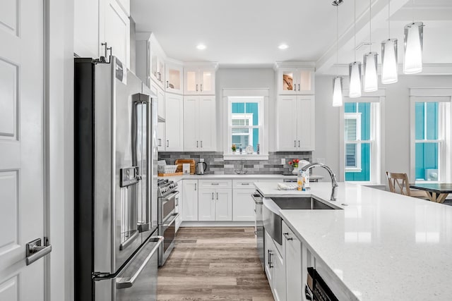 kitchen featuring sink, stainless steel appliances, tasteful backsplash, and white cabinetry