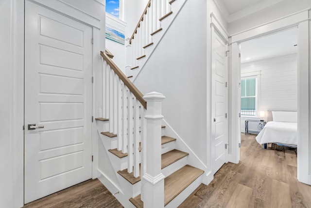 stairs with hardwood / wood-style flooring and a healthy amount of sunlight