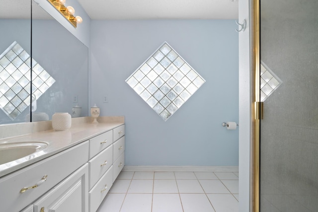 bathroom with an enclosed shower, vanity, and tile patterned floors