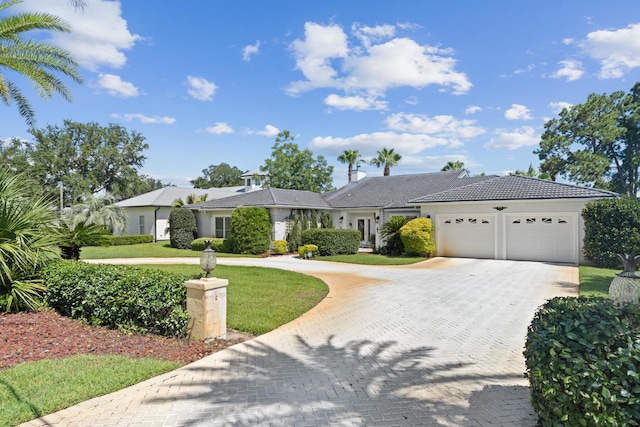 ranch-style house featuring a garage and a front yard