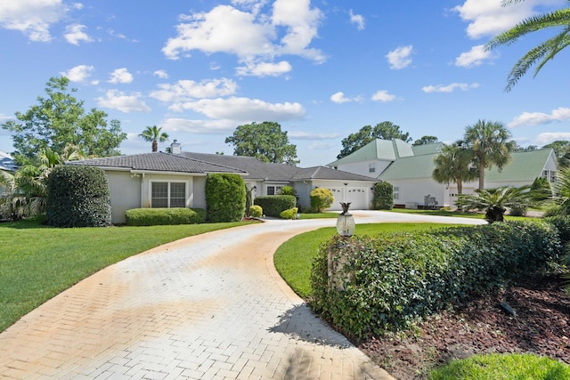 ranch-style house featuring a garage and a front yard