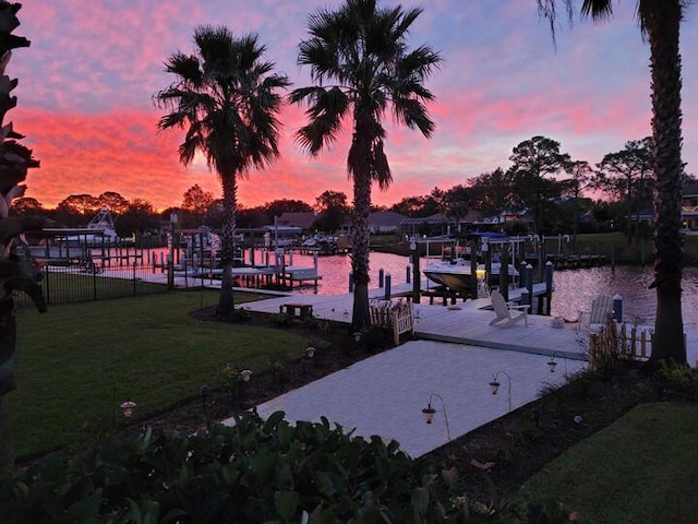 dock area featuring a water view and a lawn