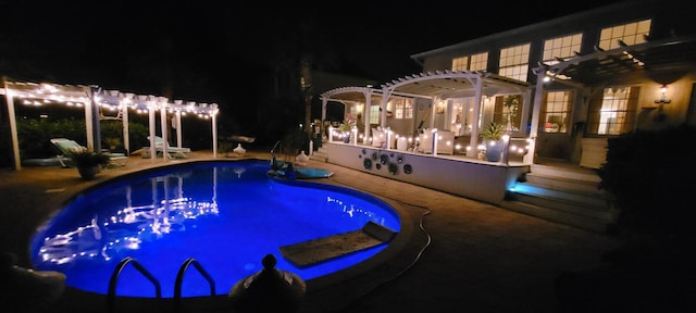 pool at twilight featuring a pergola