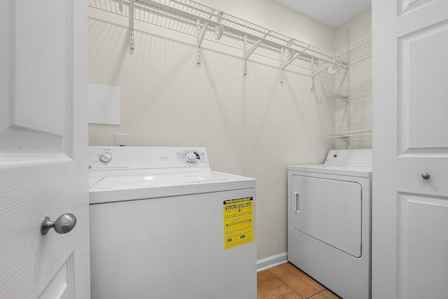 clothes washing area with light tile patterned floors and washing machine and clothes dryer