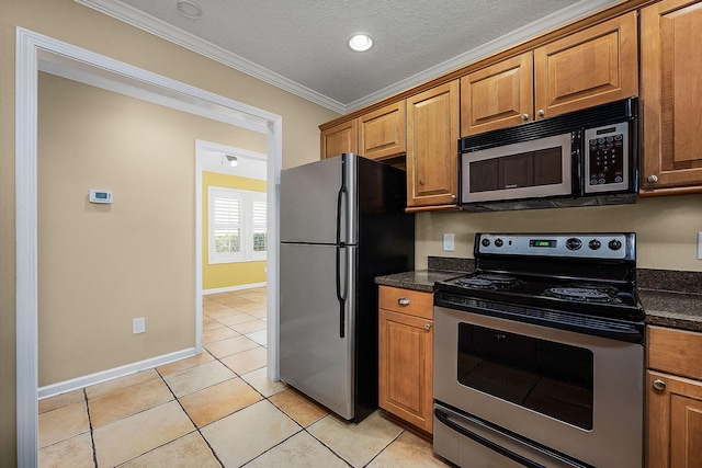 kitchen with dark stone counters, stainless steel appliances, ornamental molding, and light tile patterned floors