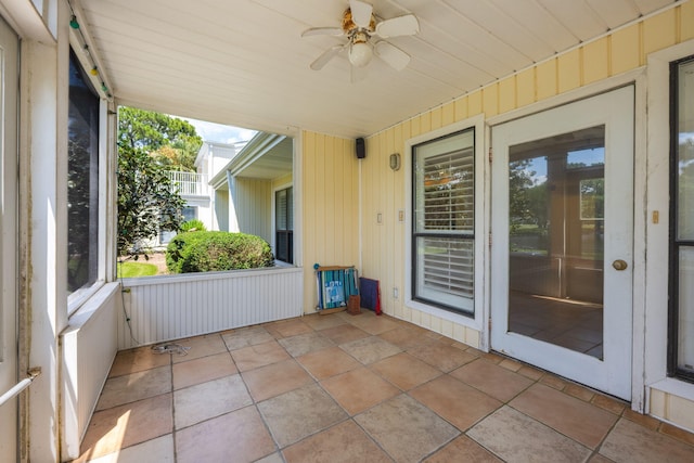 unfurnished sunroom with a healthy amount of sunlight and ceiling fan