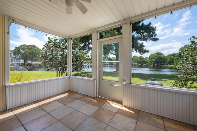 unfurnished sunroom with a water view, ceiling fan, and a wealth of natural light