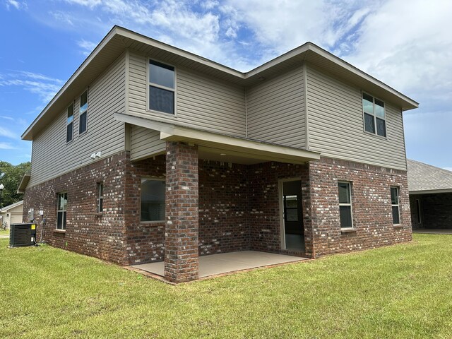 rear view of property featuring a patio, cooling unit, and a yard