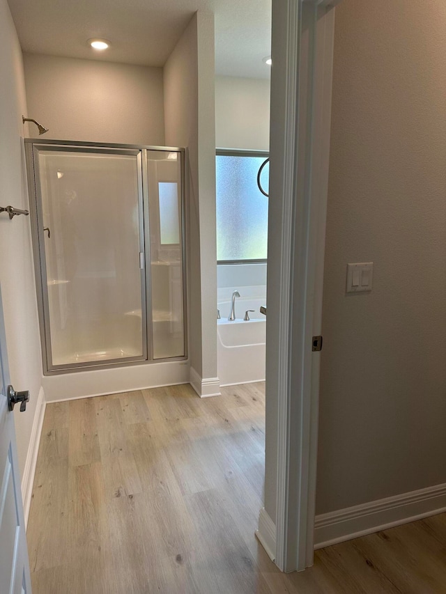 bathroom with wood-type flooring and separate shower and tub