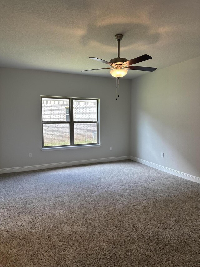 spare room featuring ceiling fan and carpet flooring