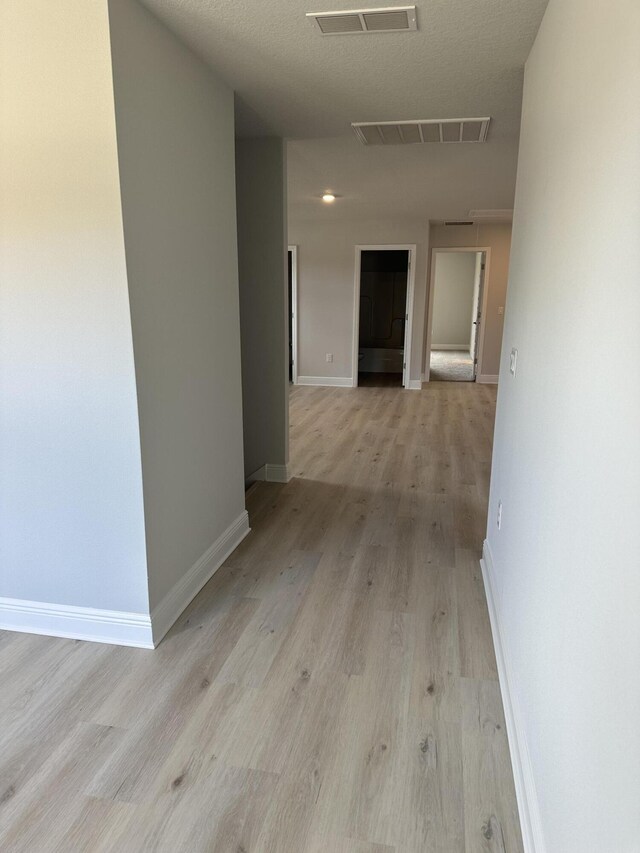 corridor with light hardwood / wood-style flooring