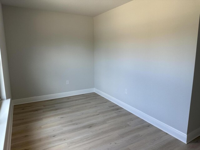 unfurnished room with hardwood / wood-style flooring