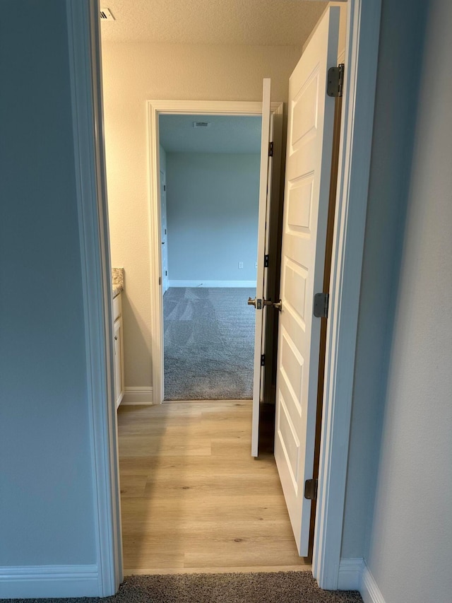 hallway with light hardwood / wood-style floors