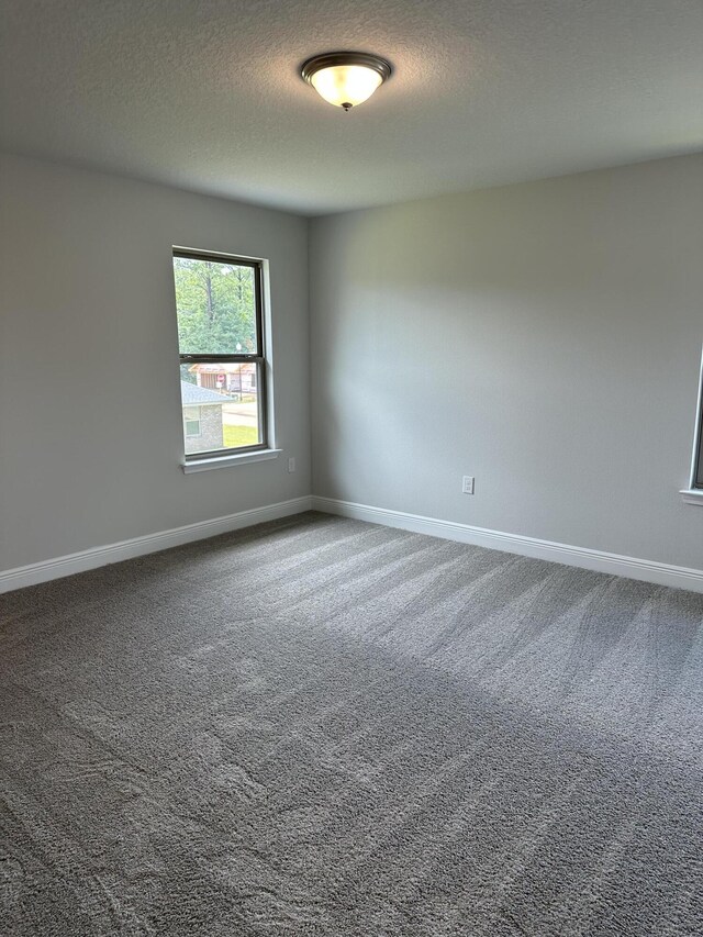 carpeted spare room featuring a textured ceiling