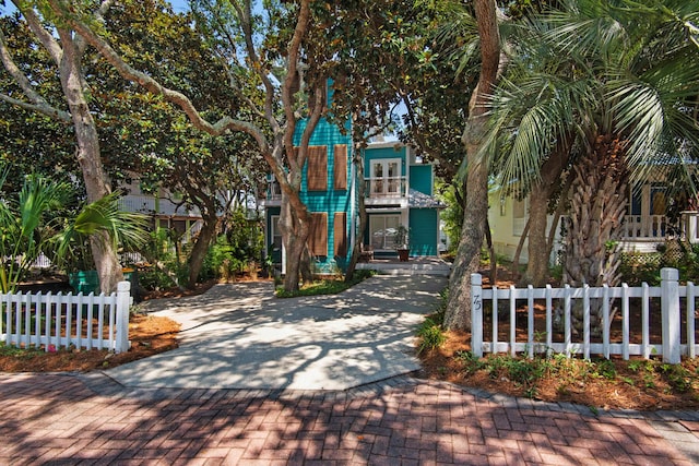 view of front of home featuring fence and a balcony