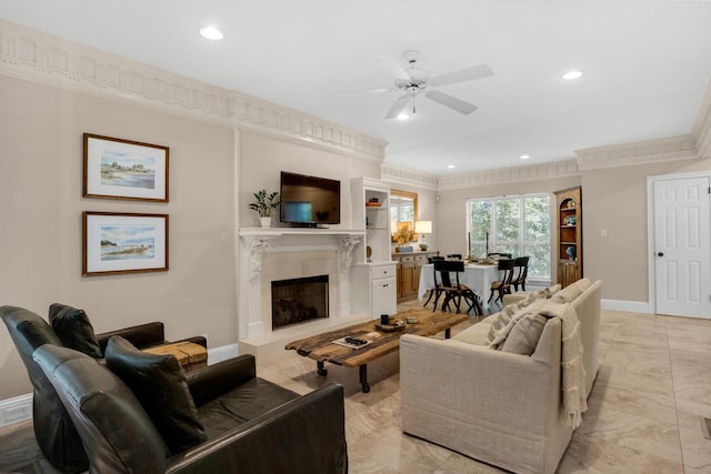 living area featuring baseboards, marble finish floor, crown molding, a fireplace, and recessed lighting