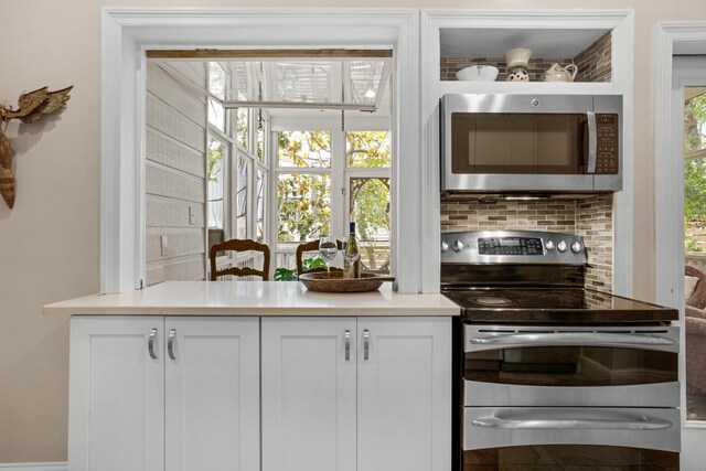 interior space with white cabinetry, stainless steel appliances, and tasteful backsplash