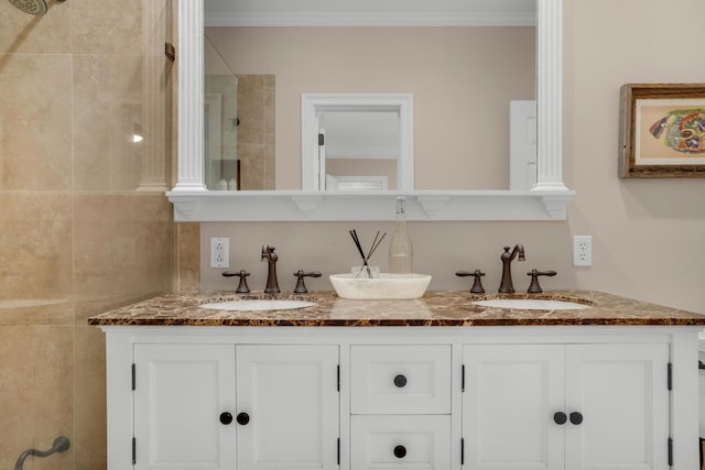 bathroom featuring ornamental molding, a sink, a tile shower, and double vanity