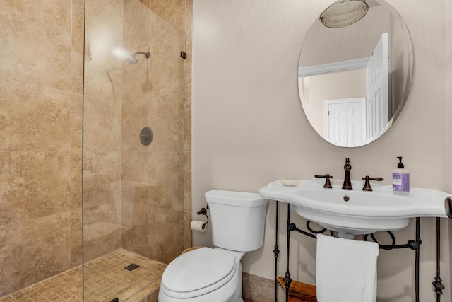 full bath featuring tiled shower and toilet