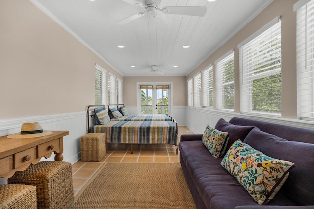 tiled bedroom featuring ornamental molding, wood ceiling, and wainscoting