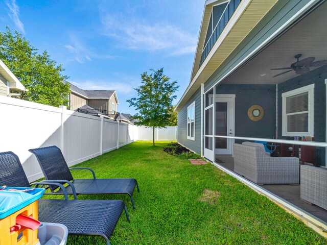 view of yard with a sunroom and ceiling fan