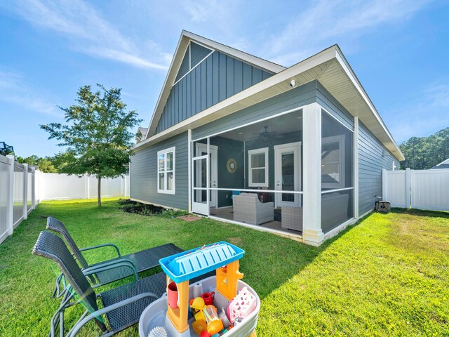 back of property with an outdoor hangout area, a sunroom, and a lawn