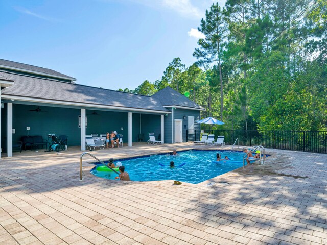 view of swimming pool featuring a patio and ceiling fan