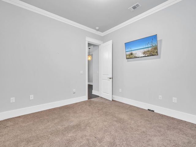 spare room featuring crown molding and carpet flooring