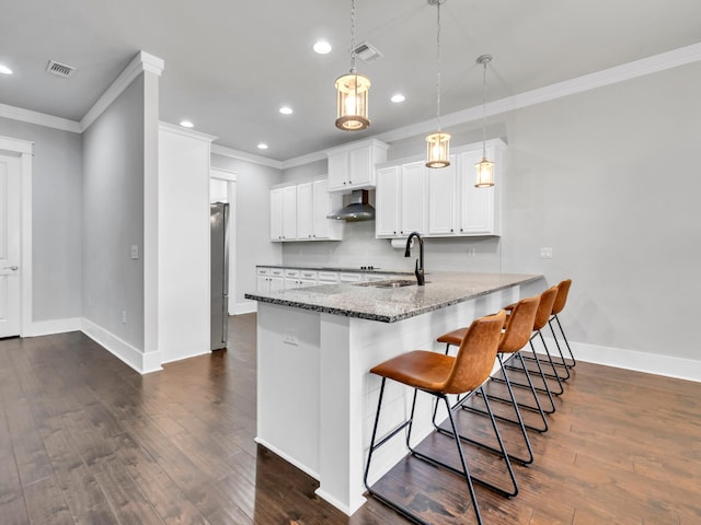 kitchen featuring sink, hanging light fixtures, light stone countertops, white cabinets, and kitchen peninsula