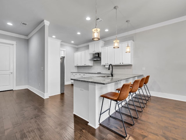 kitchen featuring pendant lighting, sink, extractor fan, white cabinets, and kitchen peninsula