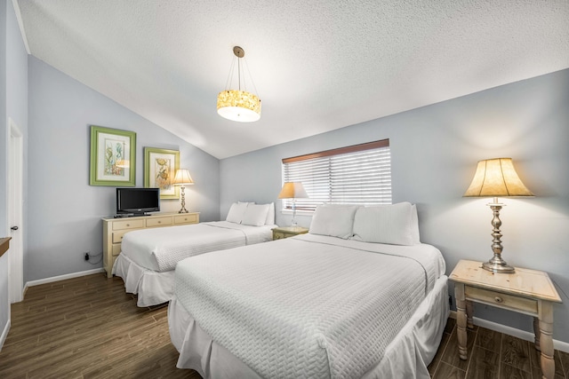 bedroom featuring lofted ceiling, dark wood-type flooring, and a textured ceiling