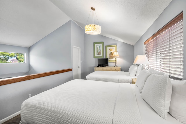 bedroom featuring vaulted ceiling and a textured ceiling