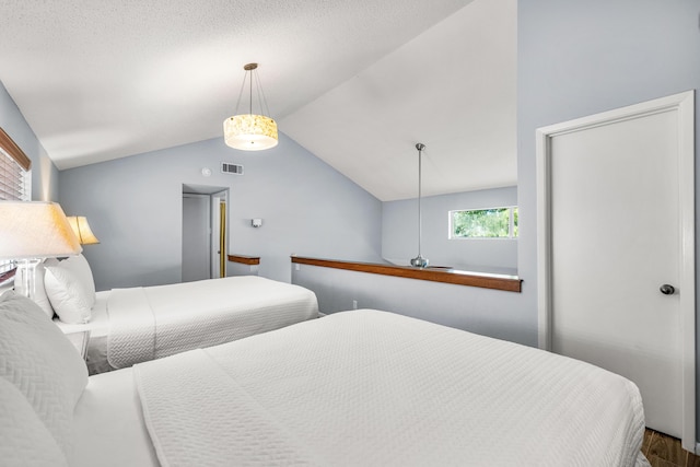 bedroom with hardwood / wood-style flooring and lofted ceiling