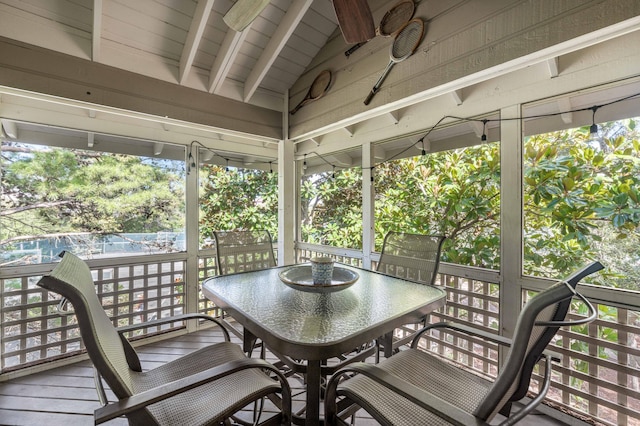 sunroom / solarium with vaulted ceiling with beams