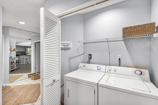 laundry area with light tile patterned floors and washing machine and dryer