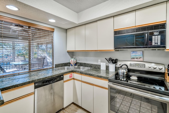 kitchen with stainless steel appliances, sink, white cabinets, and a textured ceiling