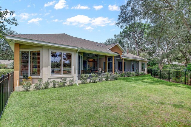 back of house with a sunroom and a yard