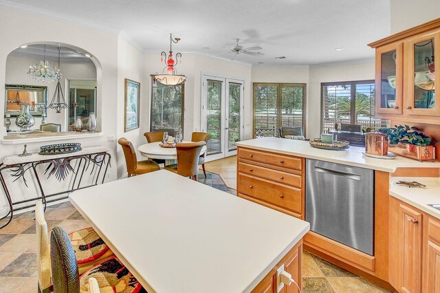 kitchen with light tile patterned flooring, ceiling fan with notable chandelier, crown molding, dishwasher, and a center island