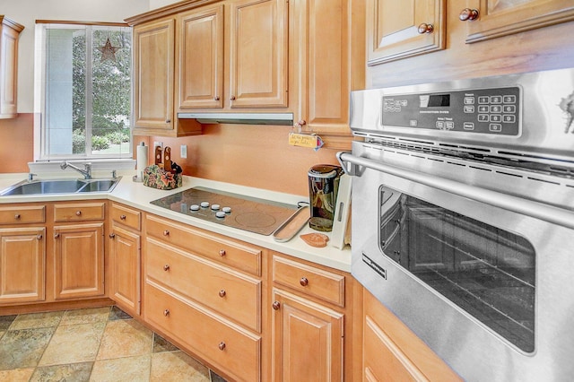 kitchen featuring sink, stainless steel oven, black electric cooktop, and light tile patterned floors