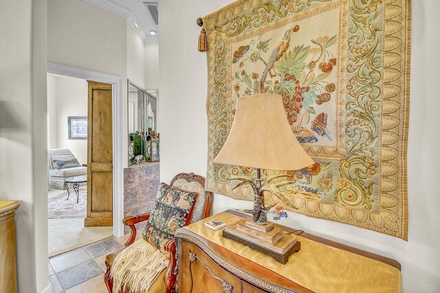 sitting room with light tile patterned floors and ornamental molding