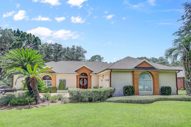 single story home with a garage and a front lawn