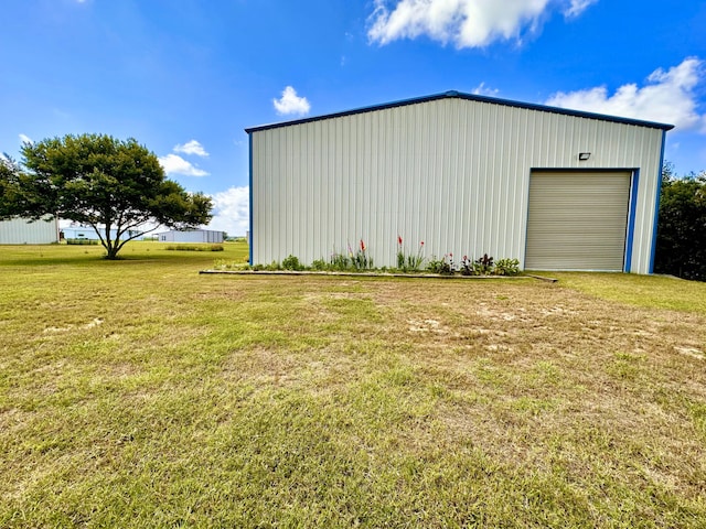 view of outbuilding with a garage and a lawn