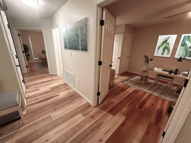 hallway with light hardwood / wood-style floors