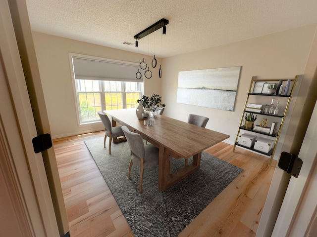 dining room featuring light hardwood / wood-style floors and a textured ceiling