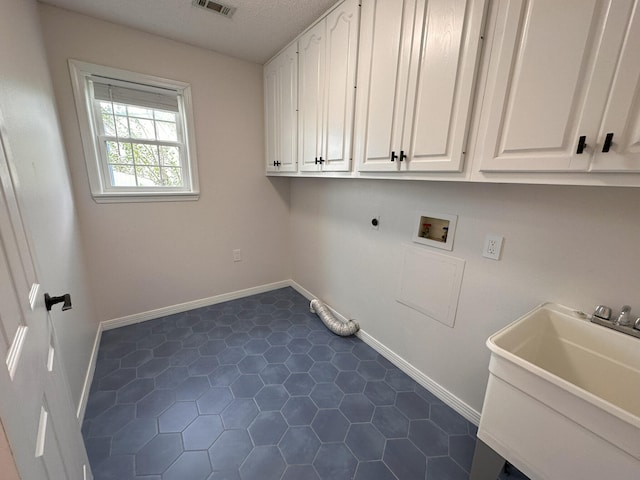 clothes washing area featuring electric dryer hookup, sink, washer hookup, and cabinets