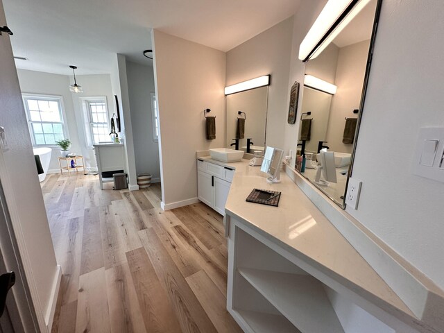 bathroom featuring wood-type flooring, a bathing tub, and vanity