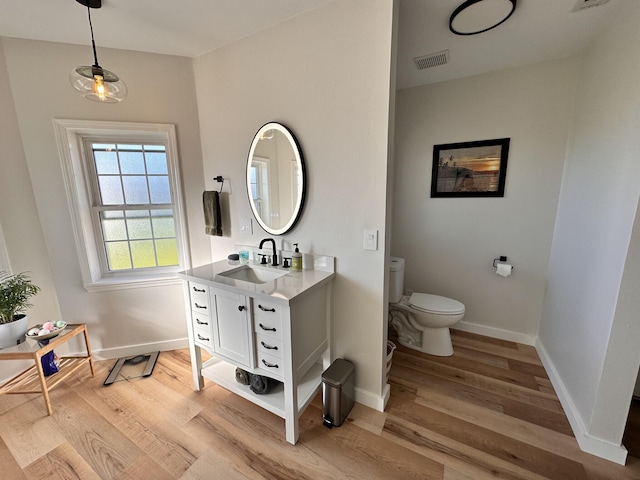 bathroom featuring vanity, hardwood / wood-style floors, and toilet