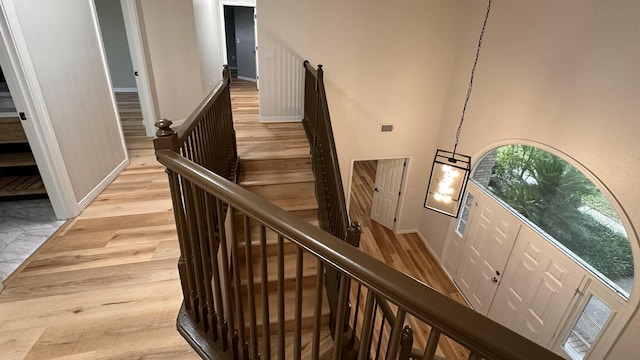 stairway featuring wood-type flooring and a high ceiling