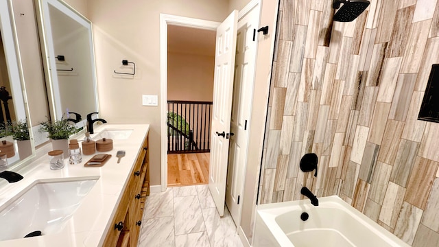 bathroom featuring tiled shower / bath combo and vanity