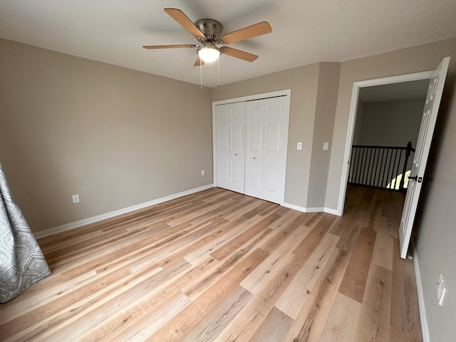 unfurnished bedroom with ceiling fan, a closet, and light wood-type flooring